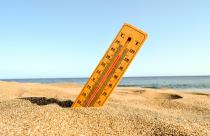 Selective focus shot of a thermometer in the beach sand with a blurred background