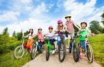 Happy kids in row wear colorful bike helmets