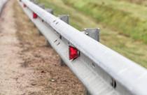 Metal guardrail mounted on a highway roadside, safety equipment