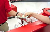 Woman receiving cash back when paying at a supermarket
