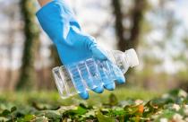 Man at plastic garbage collecting in a polluted park