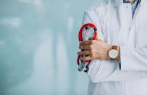 Young handsome physician in a medical robe with stethoscope