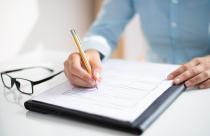 Closeup of business woman making notes in document
