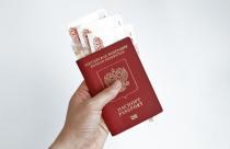 Hand holding Russian passport with 5000 rubles banknotes
