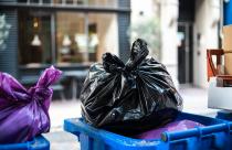 And black bags of trash on a garbage bin during daytime