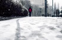 low-angle-shot-person-walking-snow-covered-sidewalk-snow_181624-21806
