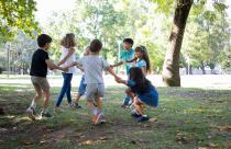 happy-children-playing-together-outdoors-dancing-around-on-grass-enjoying-outdoor-activities-and-having-fun-in-park-kids-party-or-friendship-concept