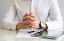 close-up-male-executive-sitting-table-with-clasped-hands_1262-16907