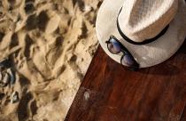 Close-up picture of hat and glasses on beach background