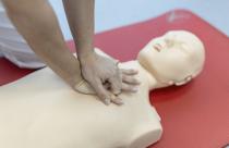 CPR class with instructors talking and demonstrating firt aid, compressions ans reanimation procedure. Cpr dummy