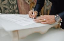 Man with a pen signs a document