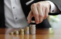 closeup-shot-of-a-businessman-s-hands-counting-stacks-of-coins-after-business-success