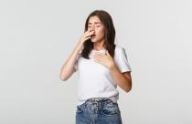 Young woman with allergy sneezing. Girl feeling sick having runny nose