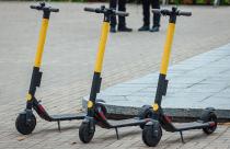 Selective focus shot of three electric scooters on the sidewalk