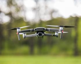 Quadcopter flying on a clear sunny green day background