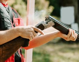 man opens the shotgun bolt after one shot with smoke