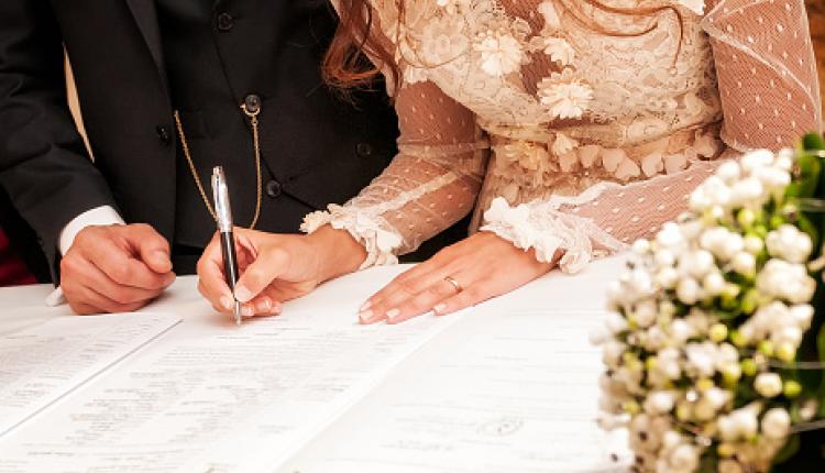 Detail of the hand of a bride who signs the marriage act