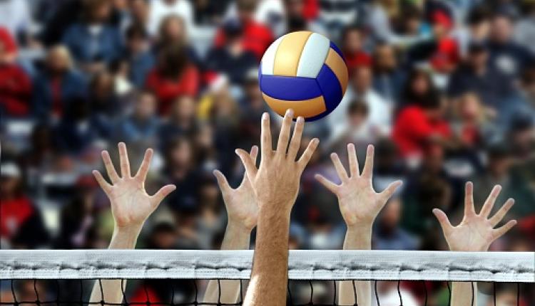 Volleyball player spike with hands blocking over the net