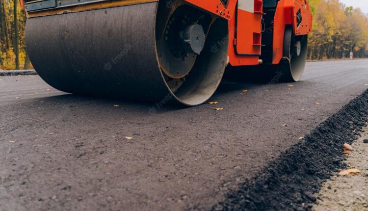 workers-operating-asphalt-paver-machine-during-road-construction-close-view-on-the-road-roller-working-on-the-new-road-construction-site_116317-916