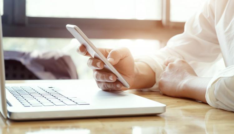 businessman-using-laptop-mobile-phone-scaled-1