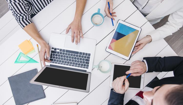 crop-coworkers-using-modern-devices-at-desk