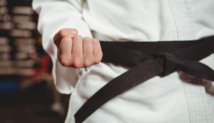 Mid section of karate player performing karate stance in fitness studio