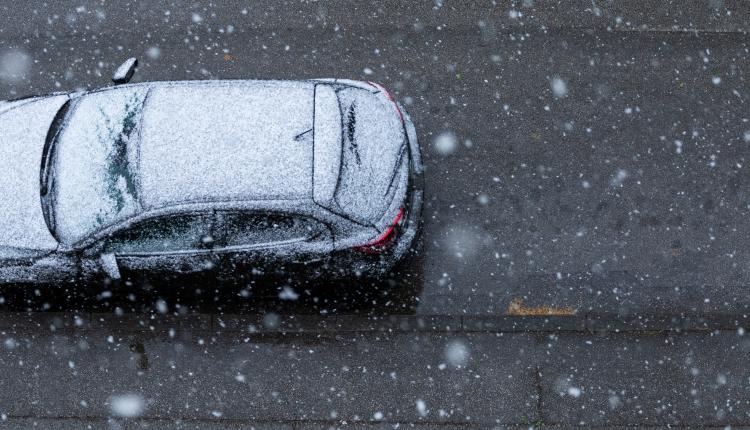 Black car on the road under the snow in spring in New Zagreb, Croatia