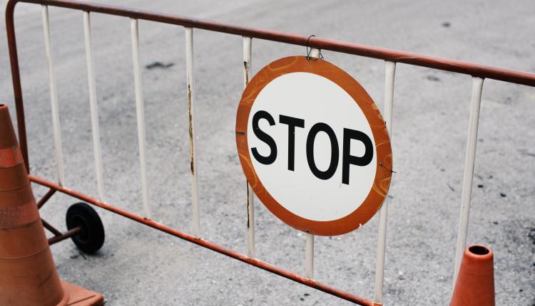 Mobile steel barrier fence with stop sign