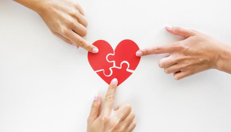 top-view-of-hands-touching-puzzle-heart-pieces