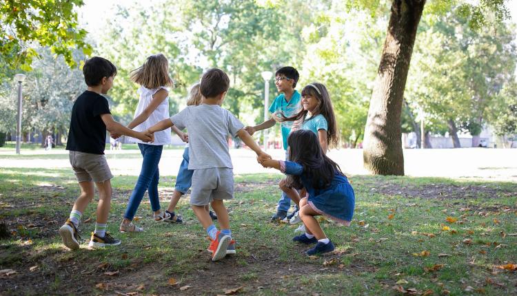 happy-children-playing-together-outdoors-dancing-around-on-grass-enjoying-outdoor-activities-and-having-fun-in-park-kids-party-or-friendship-concept