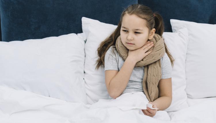 sick-girl-sitting-on-bed-with-scarf-around-her-neck-suffering-from-sore-neck