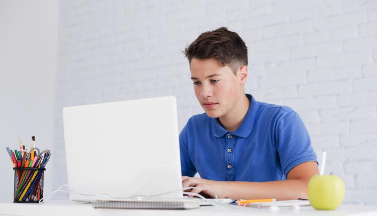 serious-guy-studying-with-laptop-desk