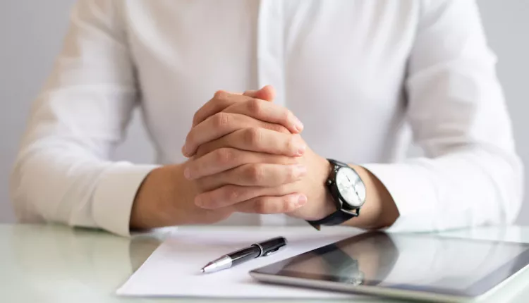 close-up-male-executive-sitting-table-with-clasped-hands_1262-16907