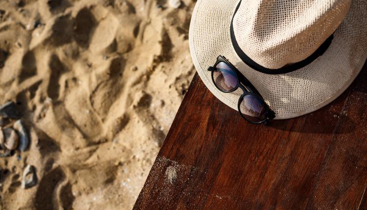 Close-up picture of hat and glasses on beach background