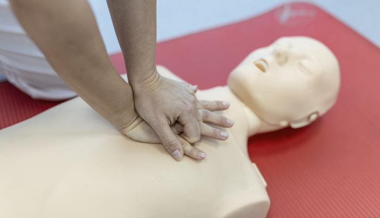 CPR class with instructors talking and demonstrating firt aid, compressions ans reanimation procedure. Cpr dummy