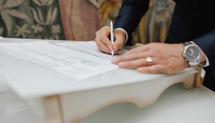 Man with a pen signs a document