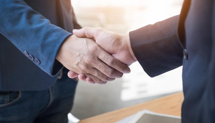 Two confident business man shaking hands during a meeting in the