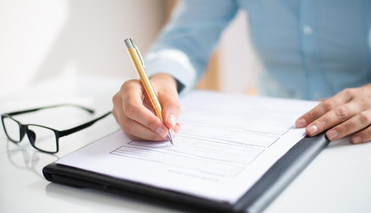 Closeup of business woman making notes in document