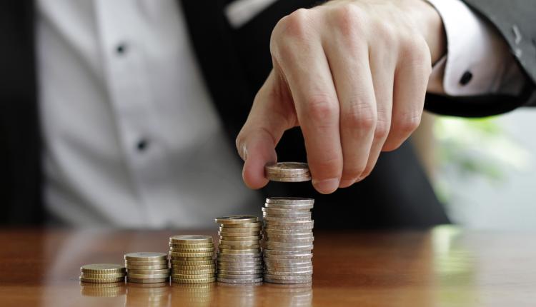 closeup-shot-of-a-businessman-s-hands-counting-stacks-of-coins-after-business-success