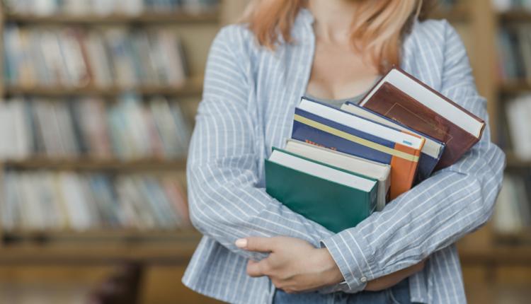 crop-teenager-hugging-books