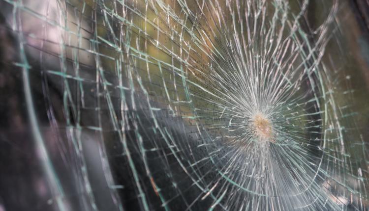 Glass broken cracks splinters in front of car . ( Filtered image
