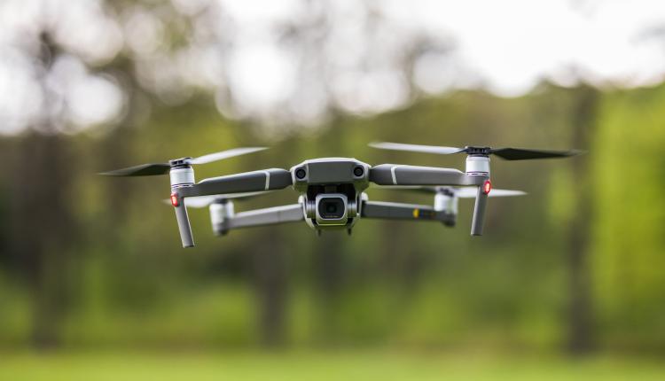 Quadcopter flying on a clear sunny green day background