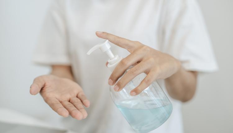 Women wearing white shirts that press the gel to wash hands to c